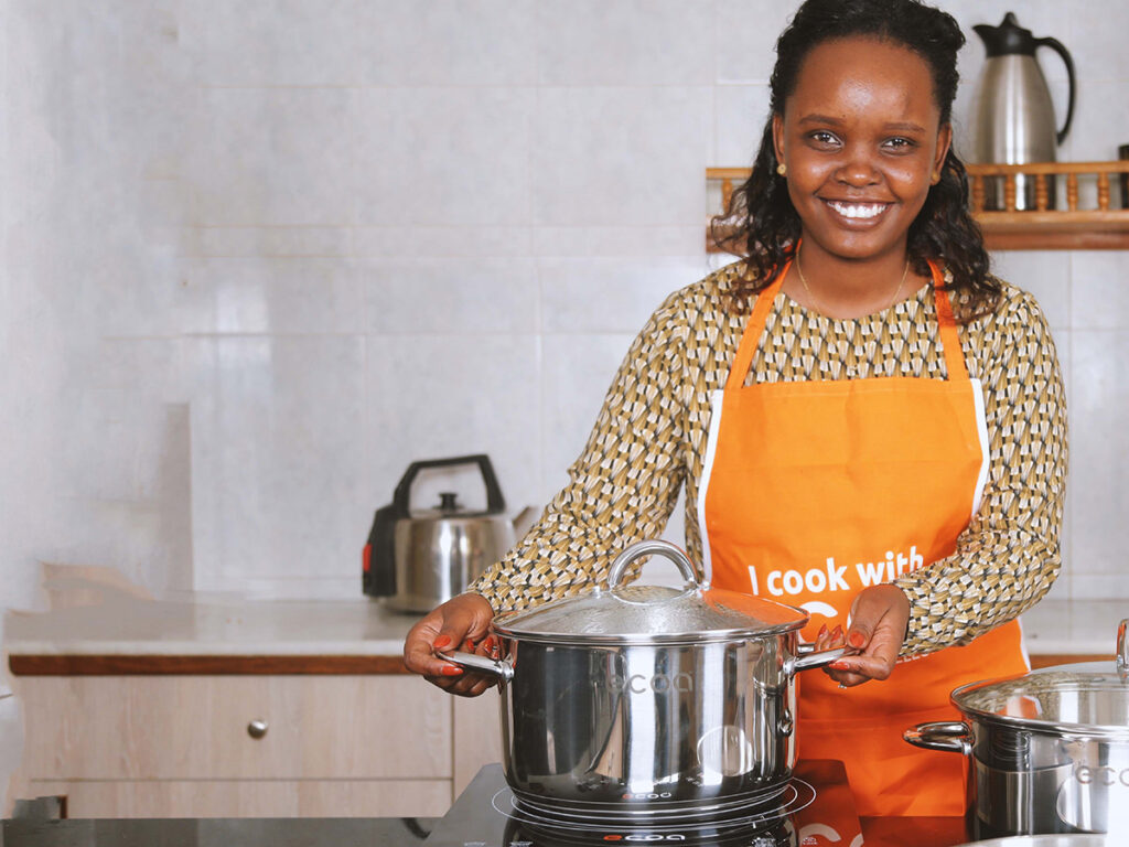 African woman cooking with BURN’s fuel-efficient clean cooking appliances